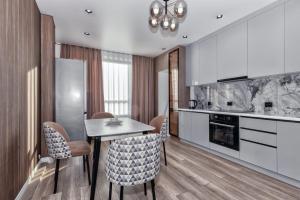Отличный вариант рядом с Новым вокзалом في أستانا: مطبخ مع طاولة وكراسي في الغرفة
