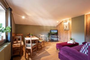 un salon avec un canapé violet et une table dans l'établissement 4-Jahreszeiten, à Hopfgarten im Brixental