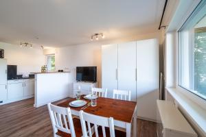 eine Küche und ein Esszimmer mit einem Holztisch und Stühlen in der Unterkunft 1-Zimmerapartment Am Hochwald in Bad Liebenzell