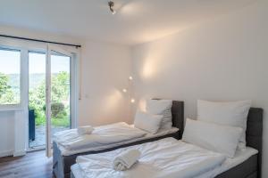 2 Betten in einem Zimmer mit Fenster in der Unterkunft 1-Zimmerapartment Am Hochwald in Bad Liebenzell