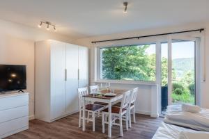 ein Esszimmer mit Tisch und Stühlen und einem Fenster in der Unterkunft 1-Zimmerapartment Am Hochwald in Bad Liebenzell