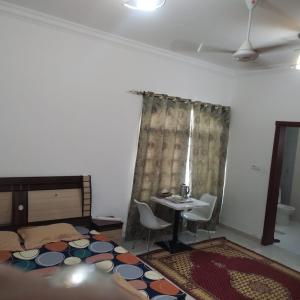 a bedroom with a bed and a table and chairs at Raha Hostel in Ḩayl Āl ‘Umayr