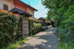 a path next to a house with a hedge at Villetta dei Pascoli in Baveno