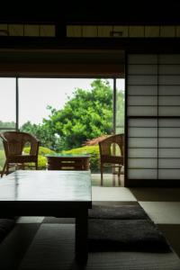 a living room with a table and chairs and a window at Sundance Resort Izu Kogen in Ito