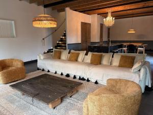 a living room with a large white couch and two chairs at Domaine du tertre ychot in Dol-de-Bretagne