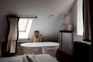 a bathroom with a bath tub and a statue of a woman at Domaine du tertre ychot in Dol-de-Bretagne +54 photos