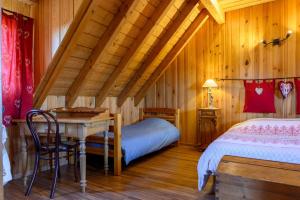Schlafzimmer mit einem Schreibtisch und einem Bett in einer Hütte in der Unterkunft Gîte À L'ancienne Boulangerie in Elsenheim