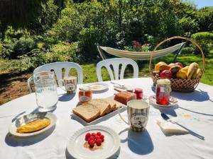 ein weißer Tisch mit Speisen und einem Obstkorb in der Unterkunft La Casa de Ethel en norte de España VV-2427-AS in Cangas de Onís + 42 Fotos