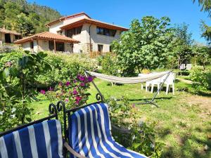 zwei Stühle und eine Hängematte in einem Hof mit einem Haus in der Unterkunft La Casa de Ethel en norte de España VV-2427-AS in Cangas de Onís