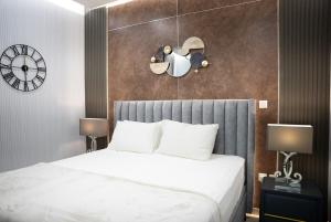 沙迦2BR Apartment in Al Zahia Sharjah- Attached to CityCenter的卧室里有一张床，墙上挂着一个钟