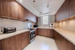 沙迦2BR Apartment in Al Zahia Sharjah- Attached to CityCenter的一个带木制橱柜和电器的大厨房