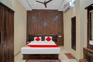 een slaapkamer met een groot bed met rode kussens bij Super Hotel O Fortune Suites in Prayagraj +17 foto's