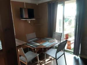 a dining room with a table and chairs and a window at Appartement avec piscine à Capesterre-Belle-Eau in Capesterre-Belle-Eau