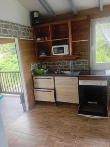 a kitchen with a stove and a microwave at Appartement avec piscine à Capesterre-Belle-Eau in Capesterre-Belle-Eau +41 photos