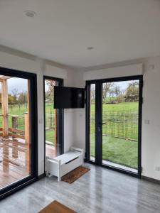 a living room with sliding glass doors and a television at Le bêêêl endroit in Gélucourt