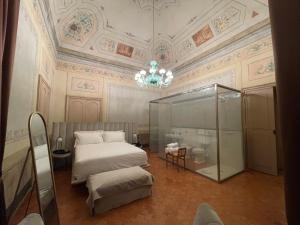 a bedroom with a bed and a chandelier at PALAZZO RICARDI Chambres d'hotes in Imperia