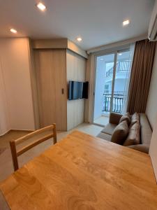 een woonkamer met een tafel en een bank bij Olympus City Garden Condo Pattaya High Floor 8F in Ban Nong Chaeng