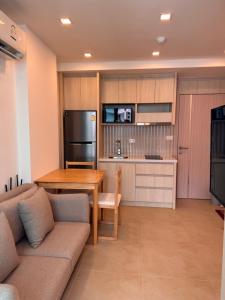 een keuken en woonkamer met een bank en een tafel bij Olympus City Garden Condo Pattaya High Floor 8F in Ban Nong Chaeng