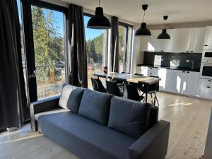 een woonkamer met een bank en een tafel met stoelen bij Harrachovský Chalet u sjezdovky  +51 foto's