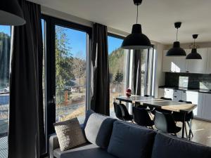 een eetkamer met een tafel en een groot raam bij Harrachovský Chalet u sjezdovky 