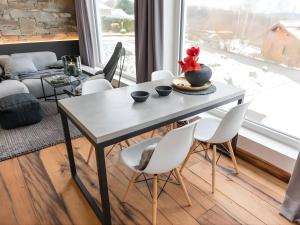 a dining room with a table and white chairs at N8Quartier Eifel in Bad Münstereifel