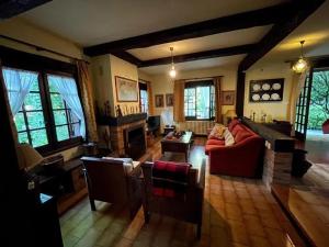 a living room with a red couch and a fireplace at Spacious Villa with Pool in Cabeanca 250 m² in Ourense