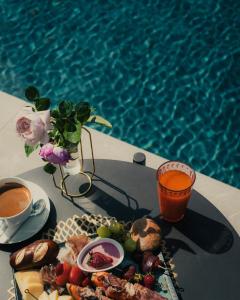 uma bandeja de comida numa mesa ao lado de uma piscina em Ansitz Battisti Suites em Caldaro