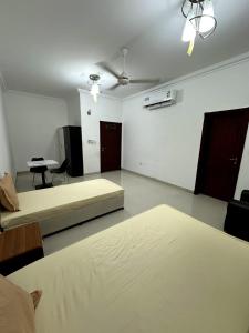 a room with two beds and a couch and a table at Raha Hostel in Ḩayl Āl ‘Umayr +5 photos
