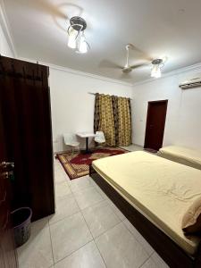 a bedroom with a bed and a table in it at Raha Hostel in Ḩayl Āl ‘Umayr