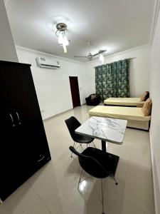 a room with a table and chairs and a bed at Raha Hostel in Ḩayl Āl ‘Umayr