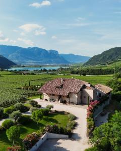 uma casa numa vinha com montanhas ao fundo em Ansitz Battisti Suites em Caldaro