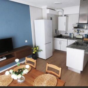 une cuisine avec une table et des chaises dans une pièce dans l'établissement La Casina Poniente,cerca de la playa, à Gijón