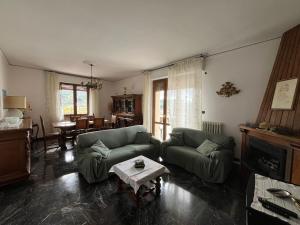 a living room with two couches and a table at Tuscany Hills Penthouse in Fivizzano