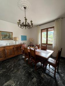 a dining room with a table and chairs and a chandelier at Tuscany Hills Penthouse in Fivizzano