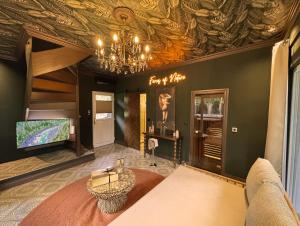 ein Wohnzimmer mit einer Decke und einem Kronleuchter in der Unterkunft Wellness Tuin - Ultieme Partner Beleving - Privé Wellness Vakantiehuis met Privé Jacuzzi in Privé tuin, Privé Indoor Sauna en Privé Indoor Stoomcabine in Koloniale Stijl - Gratis Fles Prosecco & Leuke Partner Connect Box ! in Horst