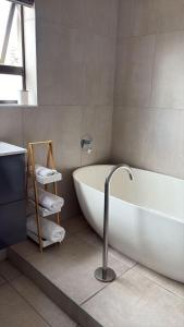 a bathroom with a white tub and a sink at Naliya Guest house in Cape Town