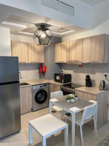une cuisine avec une table, des chaises et un réfrigérateur dans l'établissement Convenient studio in the centre of Dubai, à Dubaï