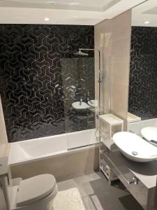 La salle de bains est pourvue de 2 lavabos, d'une douche et de toilettes. dans l'établissement Convenient studio in the centre of Dubai, à Dubaï