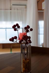 a vase with red flowers in it on a table at Howa Apt 303 in Kyoto