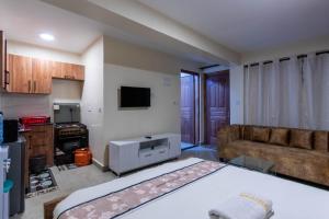 Una sala de estar con una cama grande y un sofá. en Rustic Studio with free WI-FI, en Nanyuki