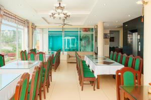a dining room with tables and green chairs at Orient Tam Đảo Hotel in Tam Ðảo