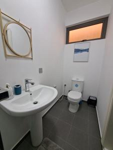 a bathroom with a white sink and a toilet at So Chic Family Villa in Flic-en-Flac