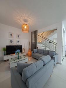 a living room with a couch and a tv at So Chic Family Villa in Flic-en-Flac