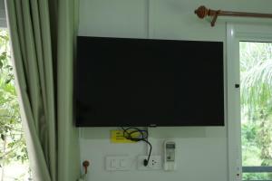a flat screen tv hanging on a wall next to a window at Palm tree garden house NinemintoAonangbeach in Ao Nam Mao
