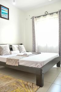 two beds in a bedroom with a window at Buxton Point Mombasa in Mombasa