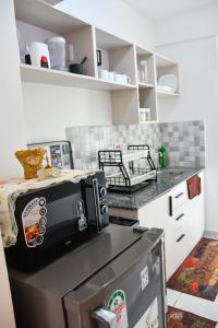 a kitchen with a microwave on top of a refrigerator at Buxton Point Mombasa in Mombasa
