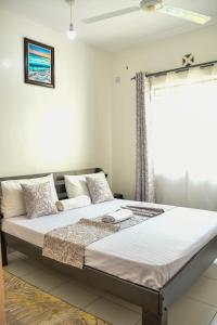 a large bed in a room with a window at Buxton Point Mombasa in Mombasa