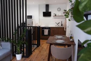 a small living room with a table and a kitchen at Charmant Duplex in Issoire +29 photos