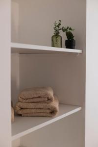 een stapel handdoeken op een plank in een badkamer bij Charmant Duplex in Issoire