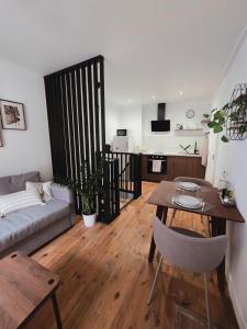 een woonkamer met een tafel en een bank bij Charmant Duplex in Issoire